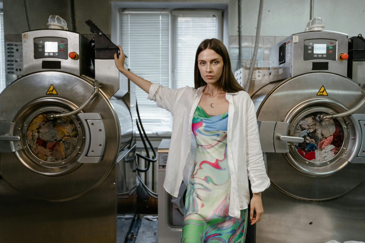Woman standing between washing machine