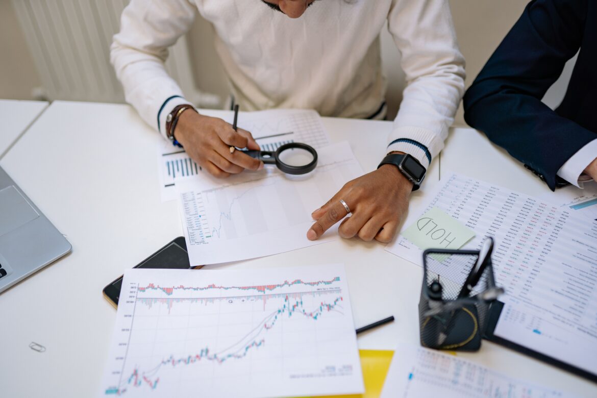 Man sitting with magnifying glass over papers