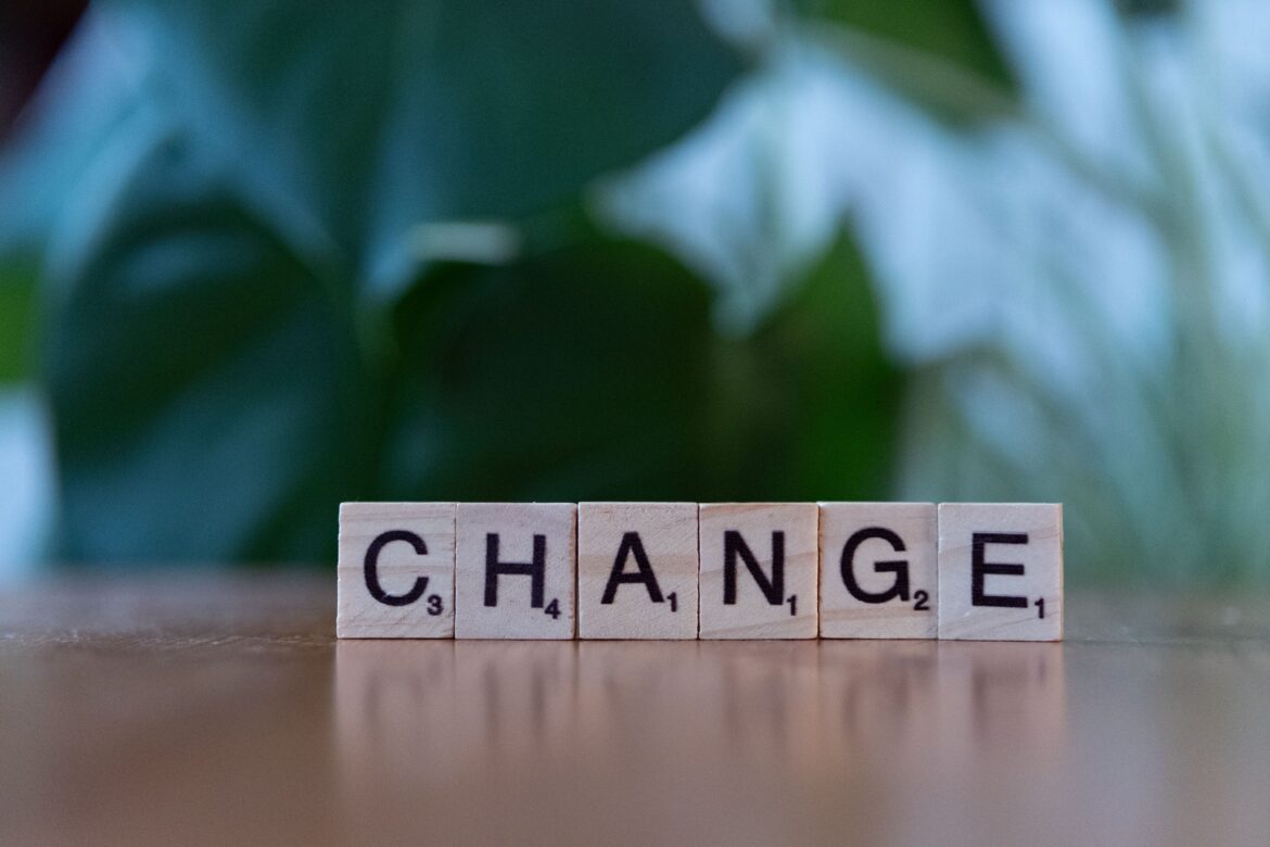 Scrabble letters spelling change on wooden surface