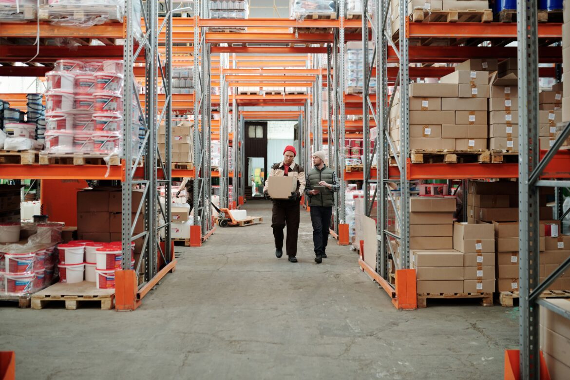 Workers walking along aisle in warehouse