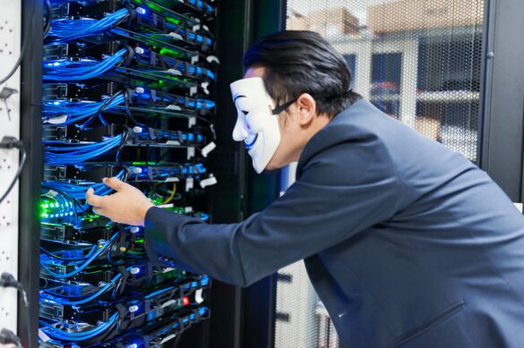 Masked person manipulating server in data center