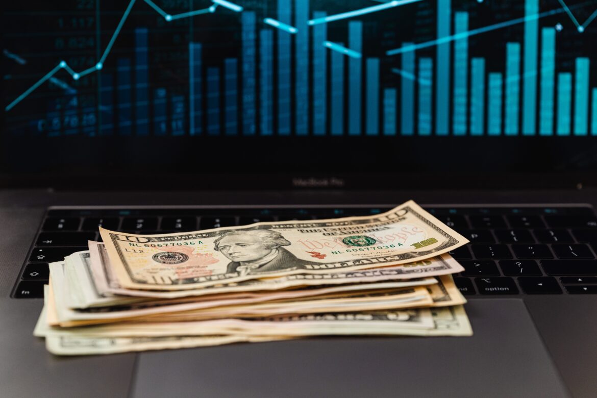 Us dollar bills on top of laptop keyboard