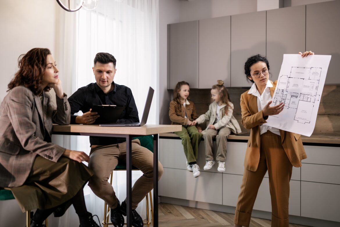 A realtor presenting a blueprint to a couple