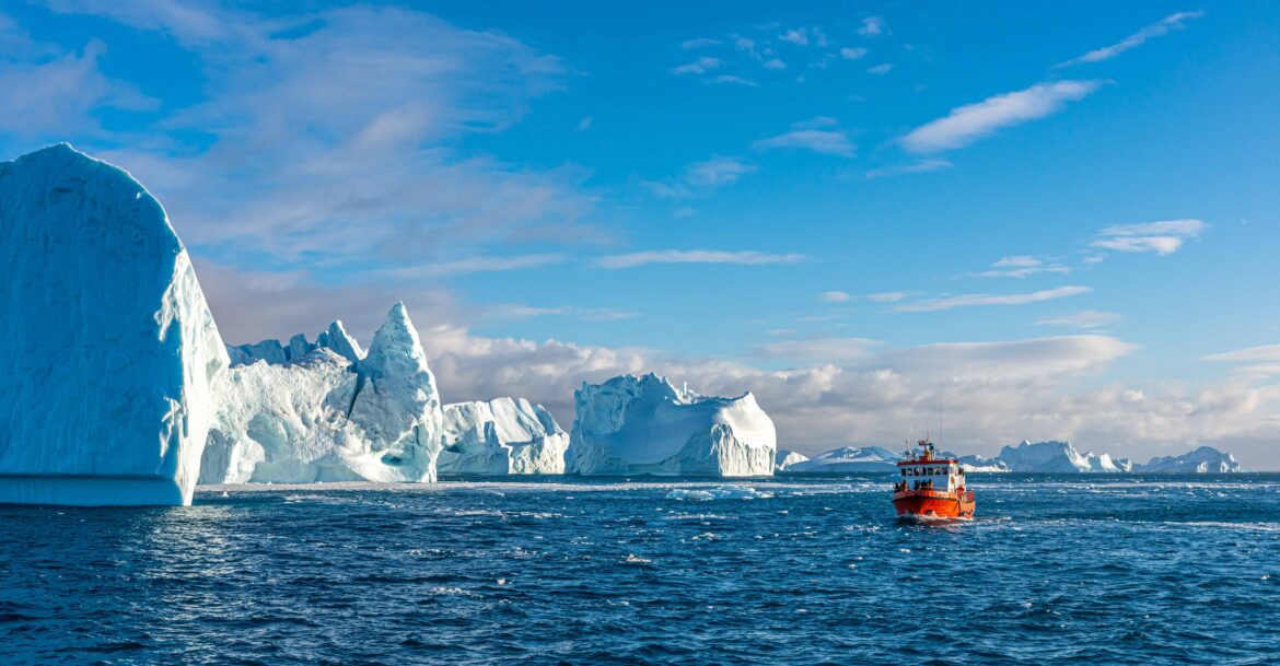 Boat sailing past icebergs