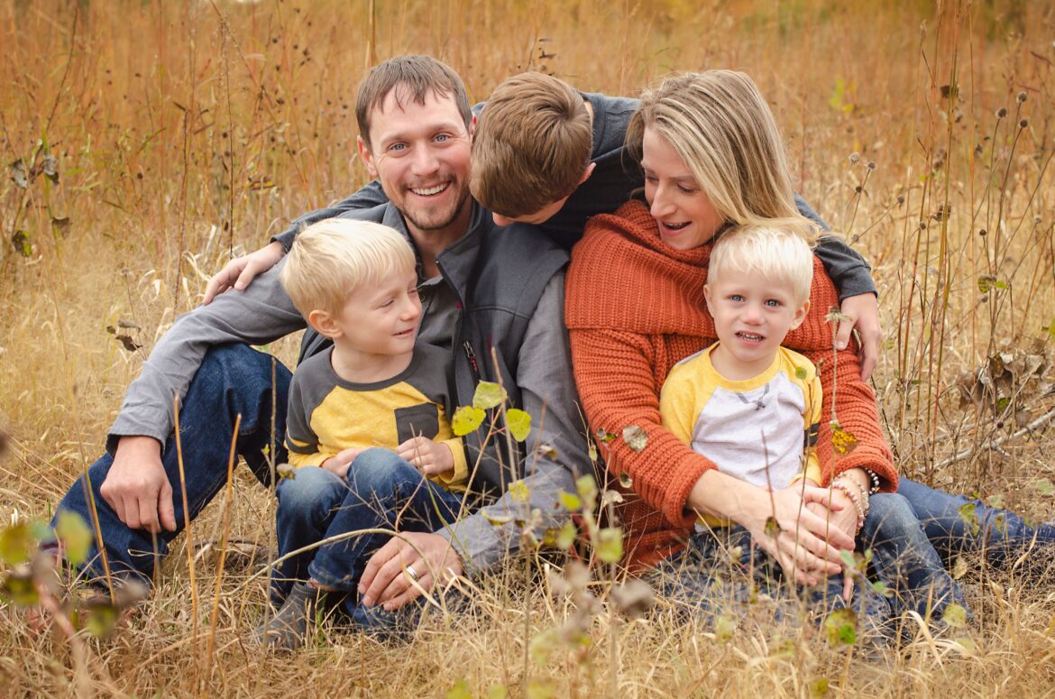 A family sitting on brown field