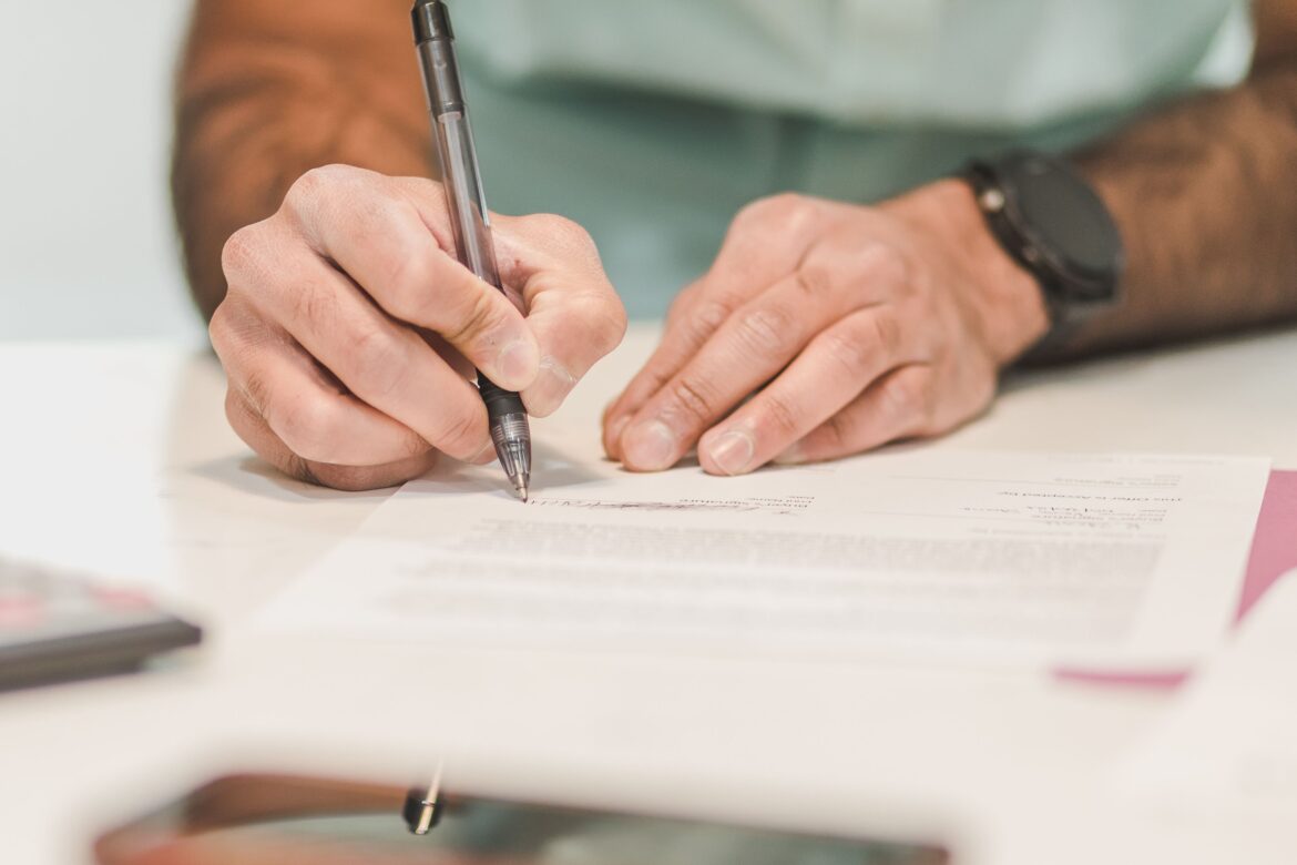 A person writing on white paper