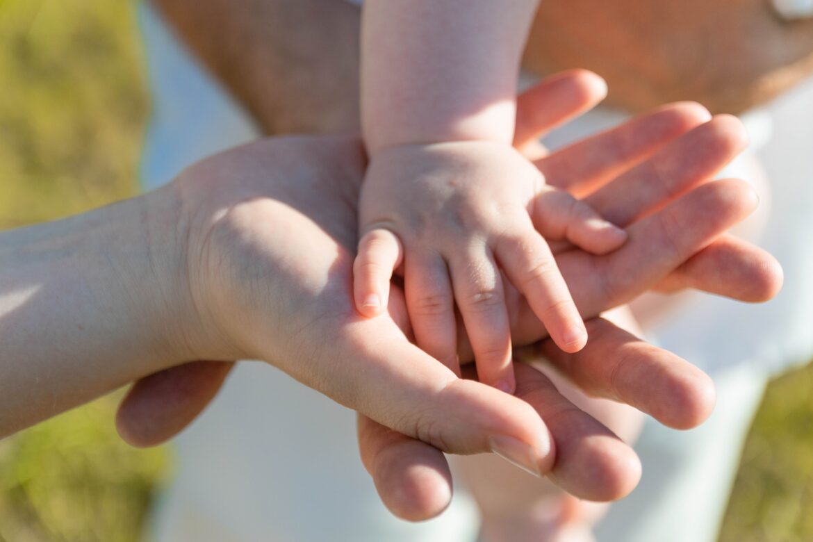 Close up photo of baby s hand on parent s hands