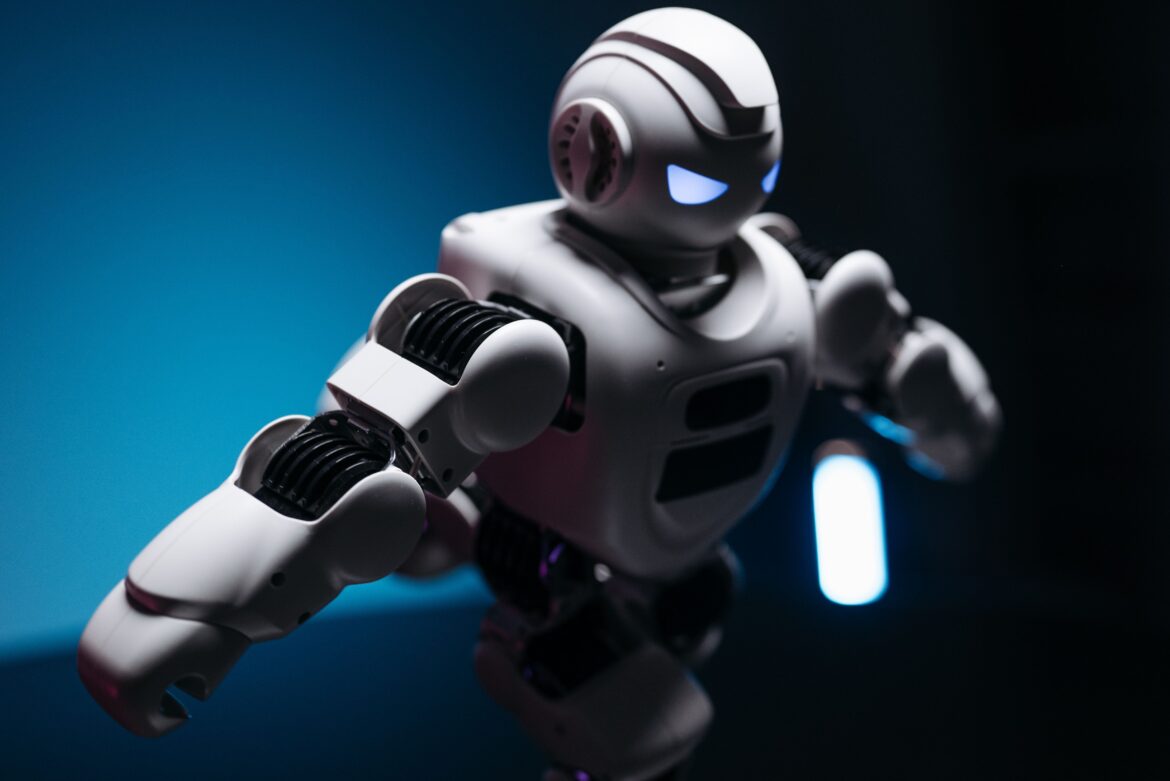Close up shot of white toy robot on blue and pink background