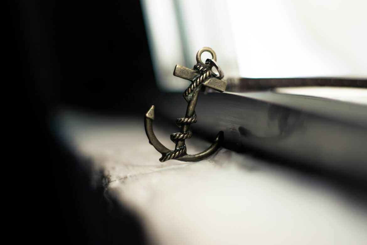 Decorative anchor shaped keyring placed on weathered windowsill