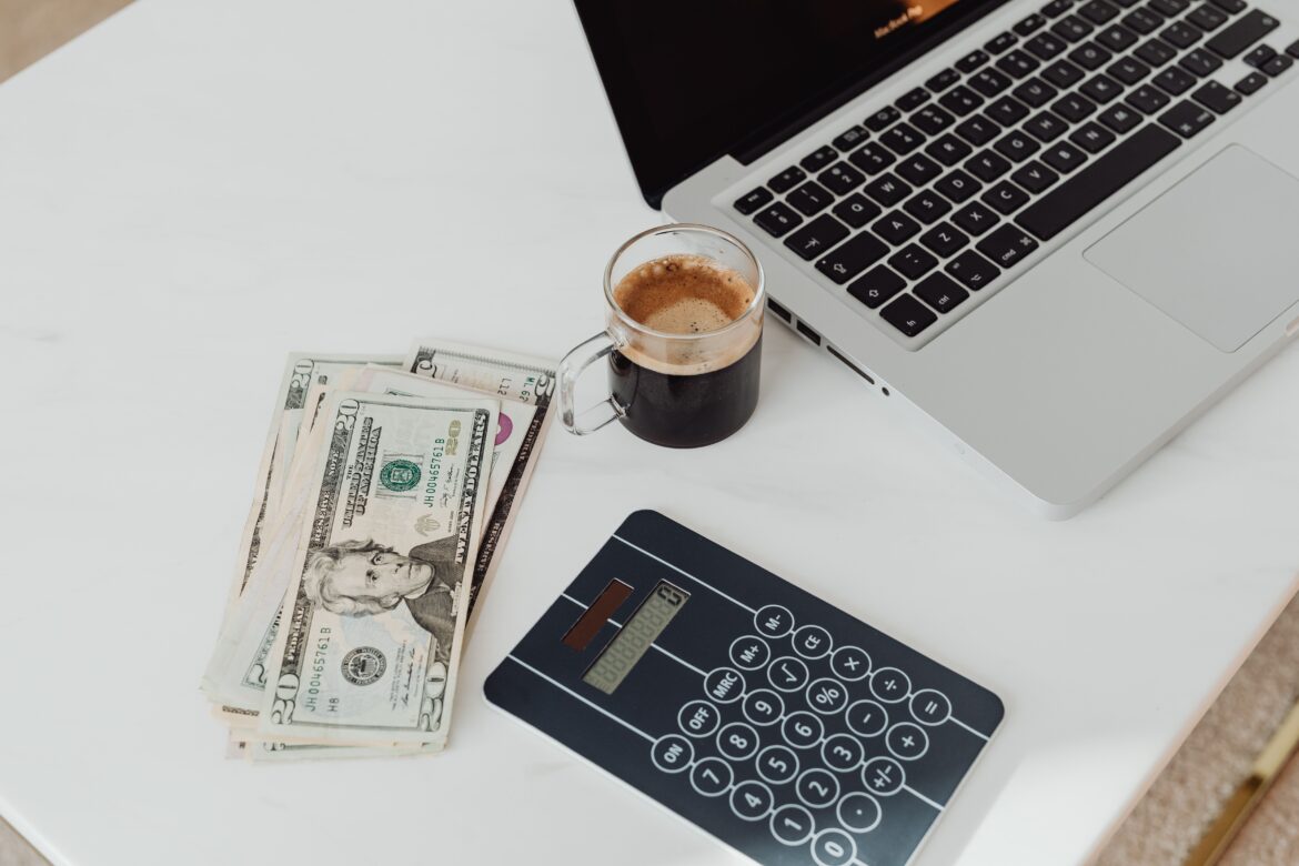 Money coffee calculator and laptop on a desk
