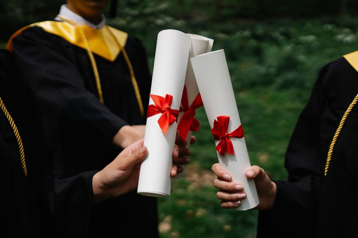 Photograph of people s hands holding white diplomas