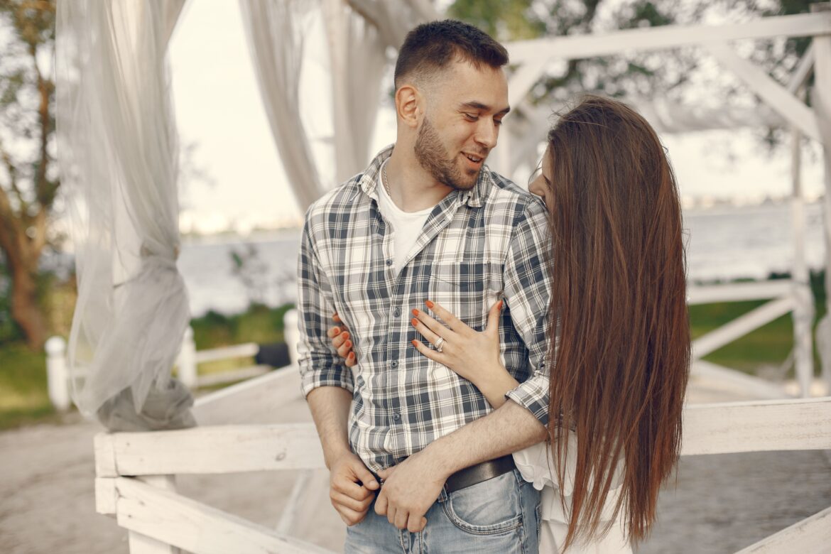 Shot of young woman hugging a man in a gazebo