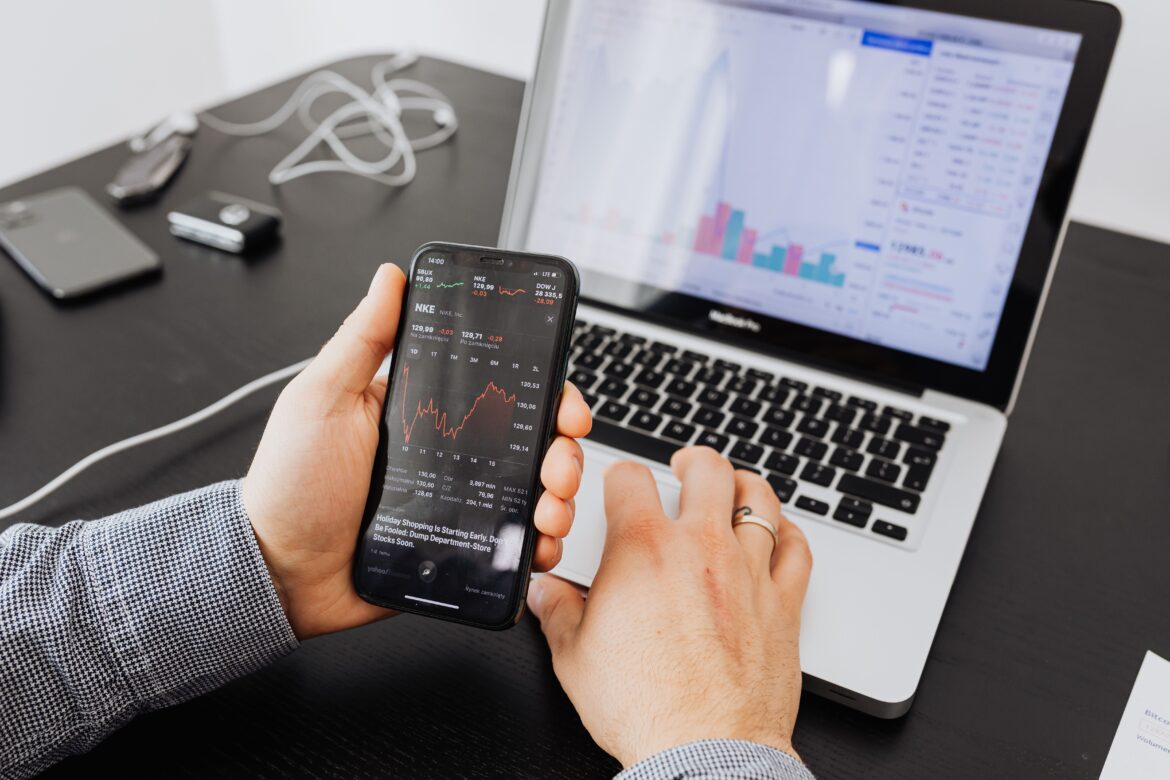 Stock market charts on phone and laptop