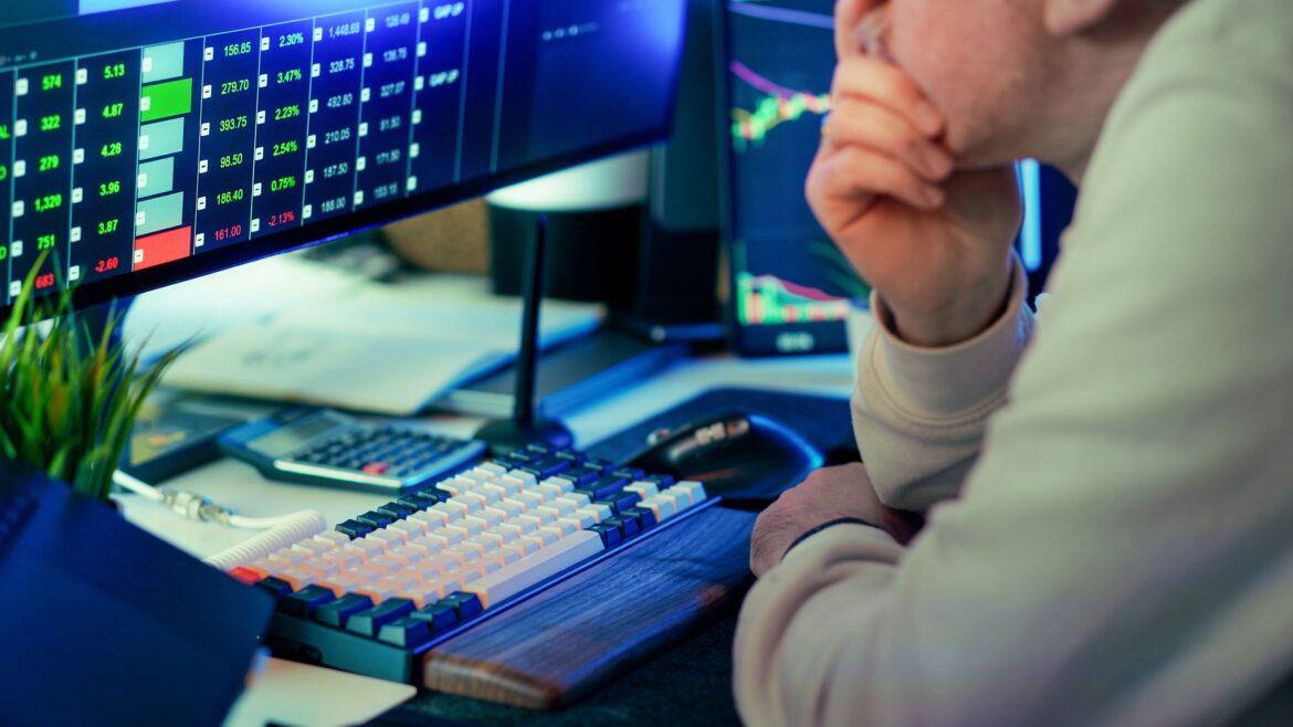 Stock trader analyzing market data on screen