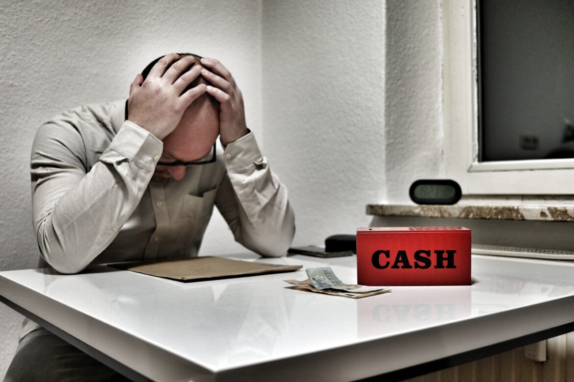 Stressed man with cash box in office setting