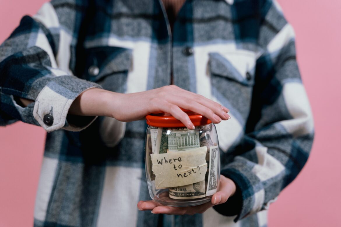 Woman in blue flannel shirt holding a glass bottle with money