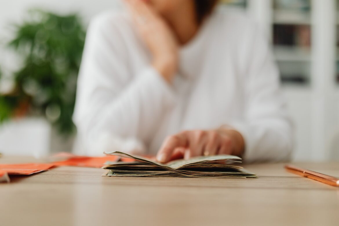 Woman sitting behind the desk and looking at money and receipts