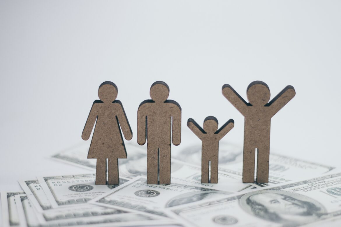 Wooden family dolls on cash